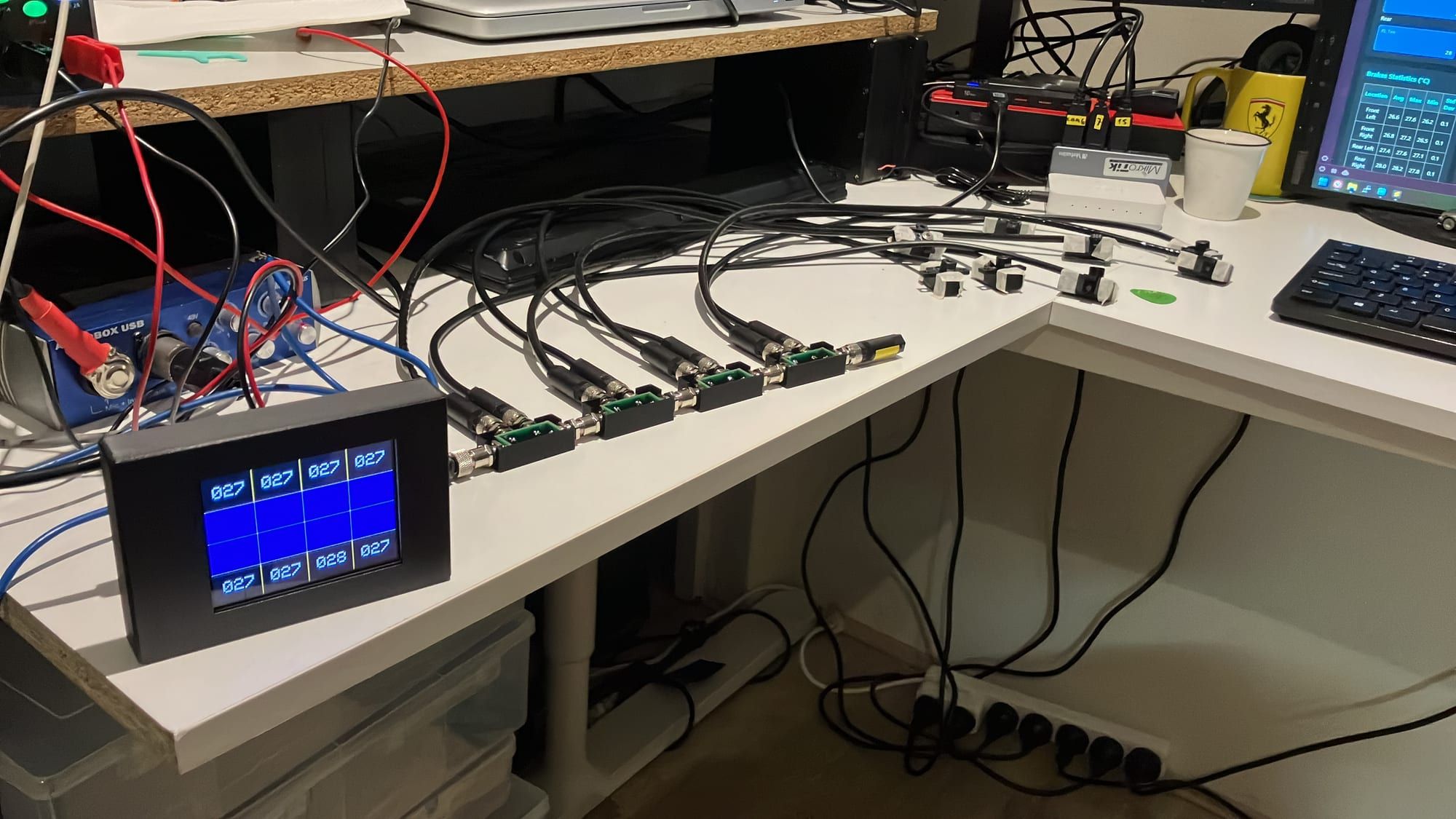 Sentinel main unit and a row of sensor nodes wired together on a workbench